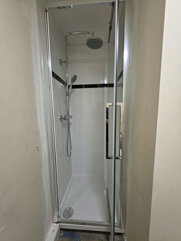 A compact shower enclosure fitted in the same space.