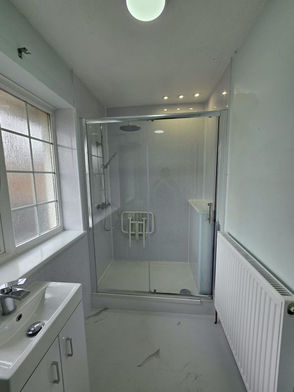 Shower room with a fold-down shower seat behind sliding glass doors